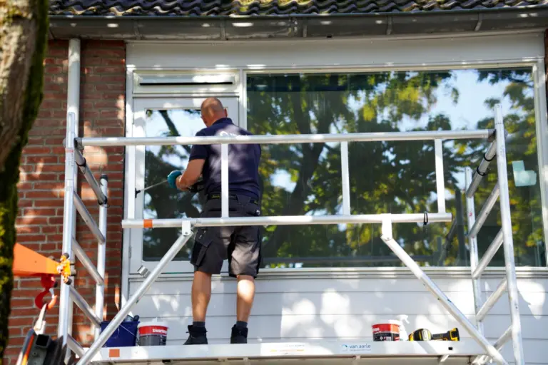 verduurzaming gevel timmerman staat op steiger